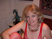 Nude in the bedroom wearing a sexy red fishnet outfit