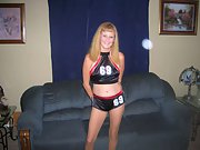 Sexy blonde in cheerleader outfit and high heel boots strips