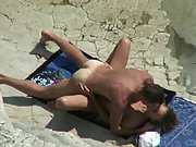 Horny couple sunbathing on a beach get excited and start action